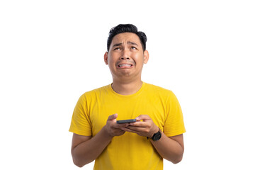 Worried young Asian man holding mobile phone and looking up with sad expression isolated on white background