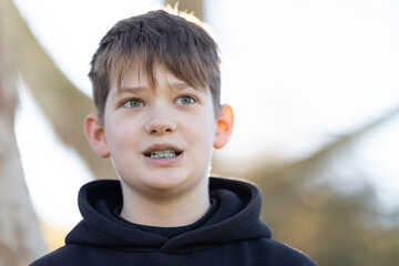 A boy with braces is smiling at the camera