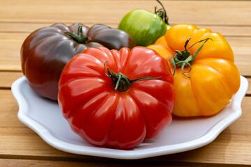 Variety of colorful tasty ripe french tomatoes from farmers market in Brittany on plate, close-up