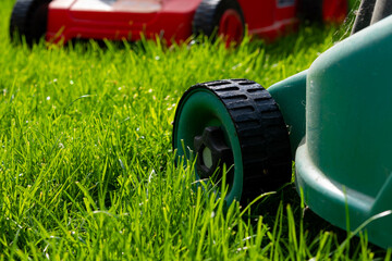 Seasonal maintenance works in garden, lawn movers in action, green grass cutting, lawn care, English lawn - 785973874
