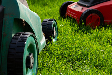 Seasonal maintenance works in garden, lawn movers in action, green grass cutting, lawn care, English lawn - 785973875