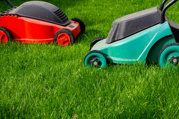 Seasonal maintenance works in garden, lawn movers in action, green grass cutting, lawn care, English lawn - 785973878