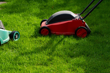 Seasonal maintenance works in garden, lawn movers in action, green grass cutting, lawn care, English lawn - 785973880