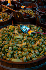 Pickled and marinated olives, artichokes, vegetables on farmers market, tasty tapas