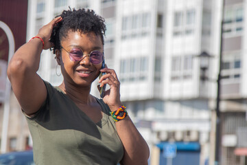 black woman posing with mobile phone on the street