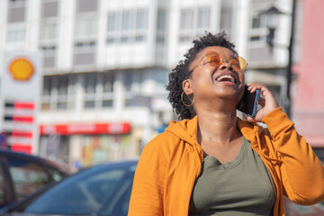 smiling african american woman talking on smartphone on the street