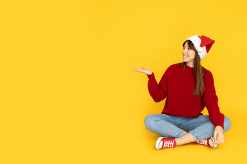 A stylish young girl in a red Christmas hat
