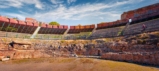 Panoramic morning view of tribunes of ancient Greco-Roman theater, Sicily, Itale, Europe. Colorful summer view of Taormina town with Teatro Antico di Taormina. Traveling concept background. - 785982695