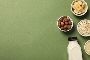 Bottle of alternative milk and herbal ingredients on green background, space for text