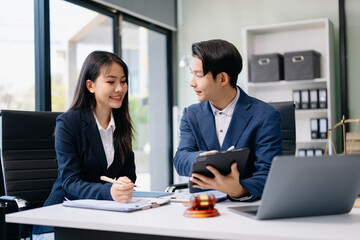 Asian business team and lawyers discussing contract papers sitting at the table. Concepts of law, advice, legal services.