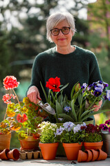 Senior woman planting flowers in the garden
