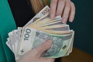 Zbliżenie na pieniądze trzymane w ręce, polska waluta złotówka w banknotach o wysokich...