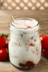 Tasty yoghurt with jam and strawberries on wooden table, closeup