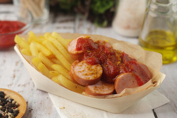 Currywurst lightly topped with curry and served with chips