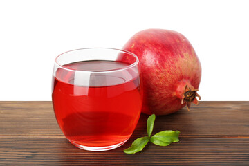 Refreshing pomegranate juice in glass, leaves and fruit on wooden table against white background