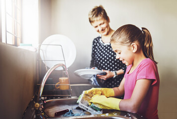 Kitchen, mother and daughter washing dishes together with help, learning or teaching at basin. Housework, mom and girl in home cleaning at sink with smile, support and morning housekeeping chores
