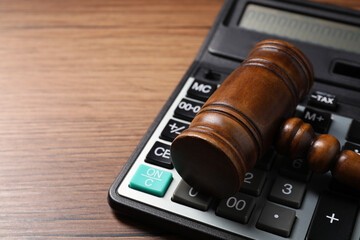 Tax law. Gavel and calculator on wooden table, closeup. Space for text