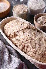 Fresh sourdough in proofing basket on table