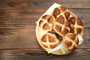 Tasty hot cross buns on wooden table, top view. Space for text
