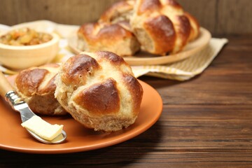 Tasty hot cross buns on wooden table, closeup. Space for text