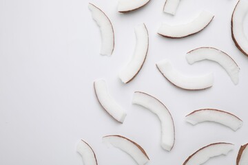 Pieces of fresh coconut on white background, top view. Space for text