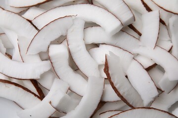 Fresh coconut pieces as background, top view