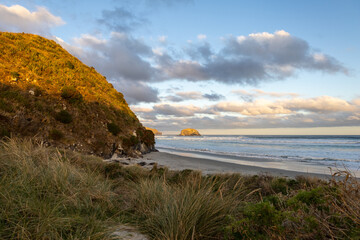 Wundersch&ouml;ner Strand im S&uuml;den von Neuseeland im Sonnenuntergang mit Wellen und Wolken