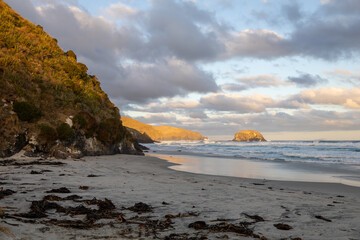 Wundersch&ouml;ner Strand im S&uuml;den von Neuseeland im Sonnenuntergang mit Wellen und Wolken