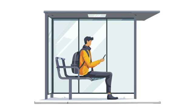 Young man sitting alone at the bus stop and using his