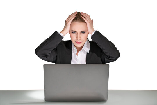 A stressed businesswoman with hands on head in front of a laptop, isolated on a white background, depicting workplace stress
