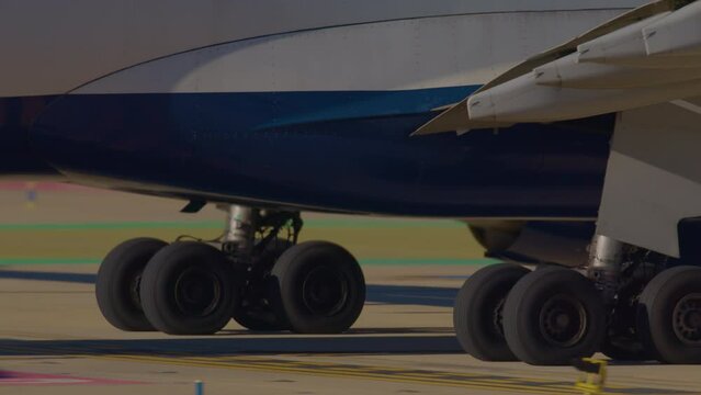 Close-up of a large airplane's landing gear with multiple wheels on a runway