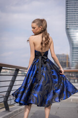 Beautiful young woman posing on the street wearing prom dress