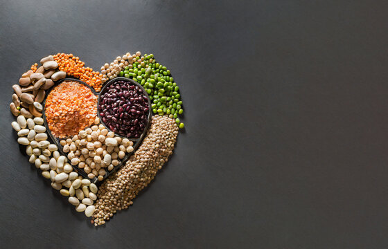 Variedad de legumbres sobre fondo oscuro con forma de coraz&oacute;n .Alimentos saludables	