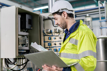 Engineers or utility staff wearing safety helmet fix the machines in the production line. Utility...