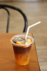 Iced orange Americano with a straw on the table