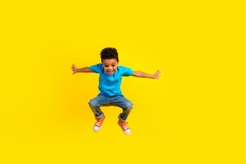 Full body photo of funky small child dressed blue t-shirt jeans flying look down empty space...