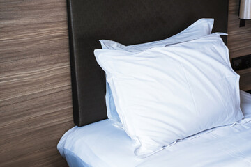 Pillows with cotton white pillowcases on a hotel bed close-up.