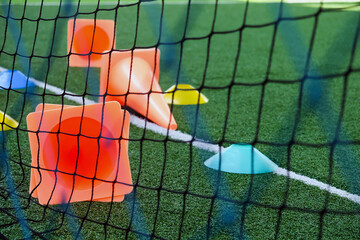 Soccer goal and cones on green artificial turf, sport background.
