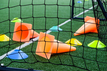Soccer goal and cones on green artificial turf, sport background.