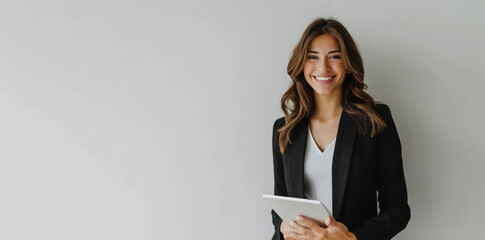 A young businesswoman, smiling, holds a digital tablet on a white background.