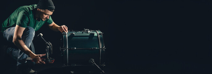 Bass drum and drummer, musical instrument on black background.