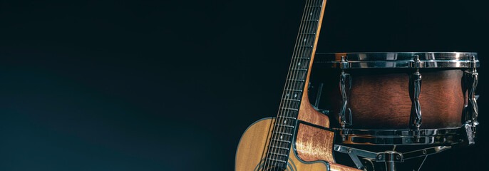 Acoustic guitar and snare drum on a black background isolated.