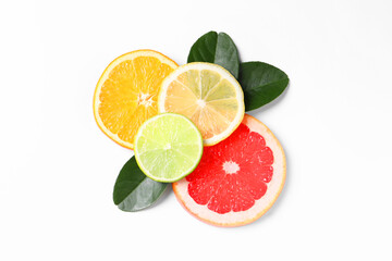 Slices of fresh ripe citrus fruits and green leaves on white background, flat lay
