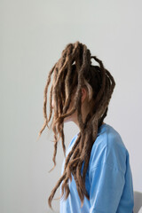 Minimal side view shot of unrecognizable young woman with freeform locks on white background