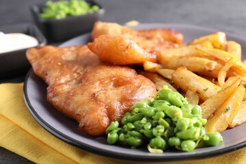 Tasty fish, chips and peas on table, closeup
