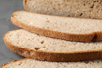 Freshly baked cut sourdough bread on grey table, closeup