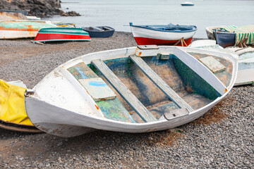 Old wooden fishing boat on the coast. Vintage fishing vessel moored at the water's edge