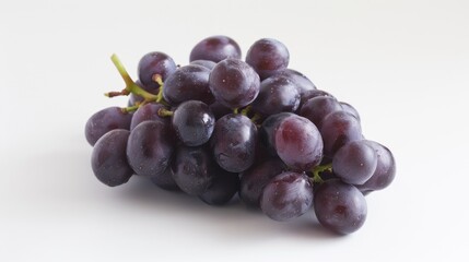 Fototapeta premium A bunch of seedless purple grapes on a white surface