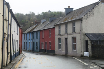 A row of painted terraced houses beside the very narrow main road through Fishguard, Pembrokeshire,...