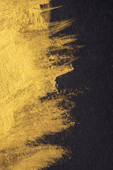 Golden paint brush stroke on black.